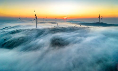 Aerial view top hill at dawn with fog covering small village in Aerial view top hill at dawn with fog covering small village in
